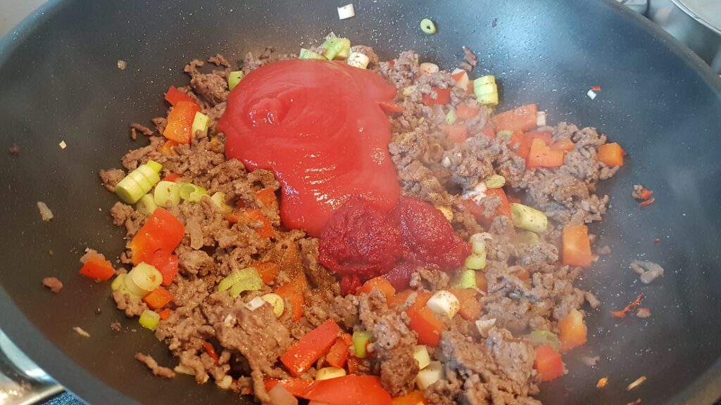 tomatenpuree en gezeefde tomaten bij het gehakt